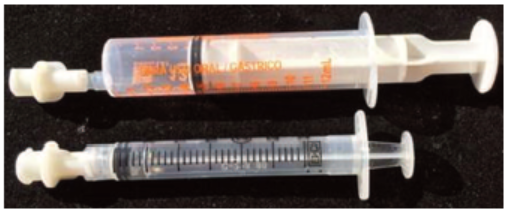 Figure 2. Above, oral syringe with add-on adapter to make it compatible with ENFit connector on feeding tube. Bottom, same add-on adapter fits on a parenteral syringe.