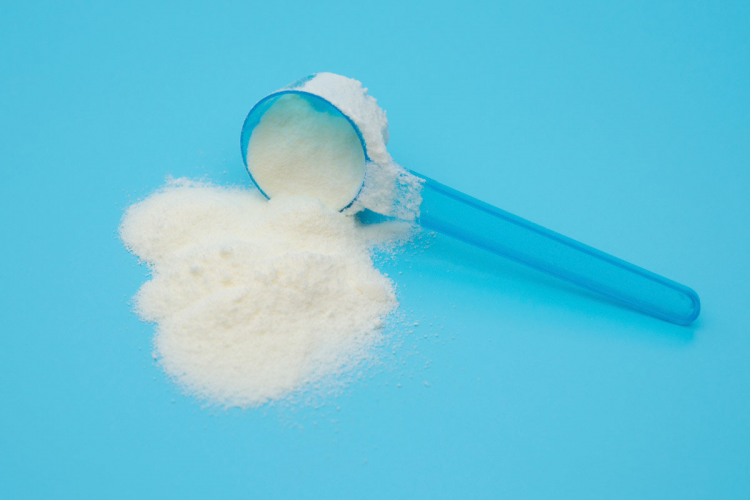 caffeine powder spilling out of a measured tablespoon
